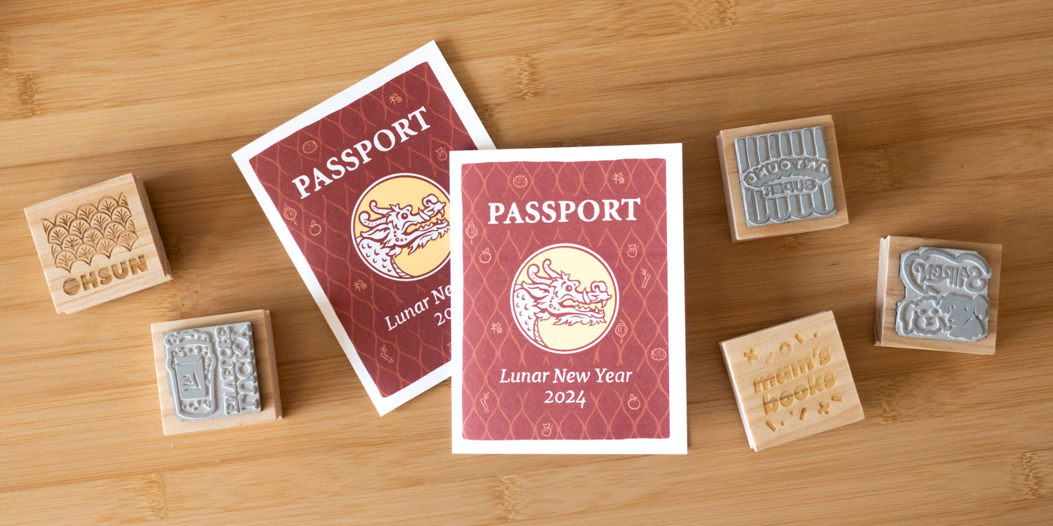 Two red-covered passport booklets (featuring a dragon within a circle and a red-patterned background), surrounded by five square rubber stamps with wood backings.