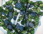 A rumpled fabric depicting an all-over pattern of blue hydrangea flowers and green leaves