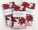 Three rectangular folded kitchen towels, all with the same red Japanese maple leaf pattern and white packaging band