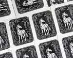 Multiple black and white blockprints tiled on a flat surface, each depicting a horse under wisteria vines.