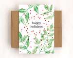 A single card with a brown envelope. The card depicts textured green leaves, red dots, and black text that reads 'happy holidays'